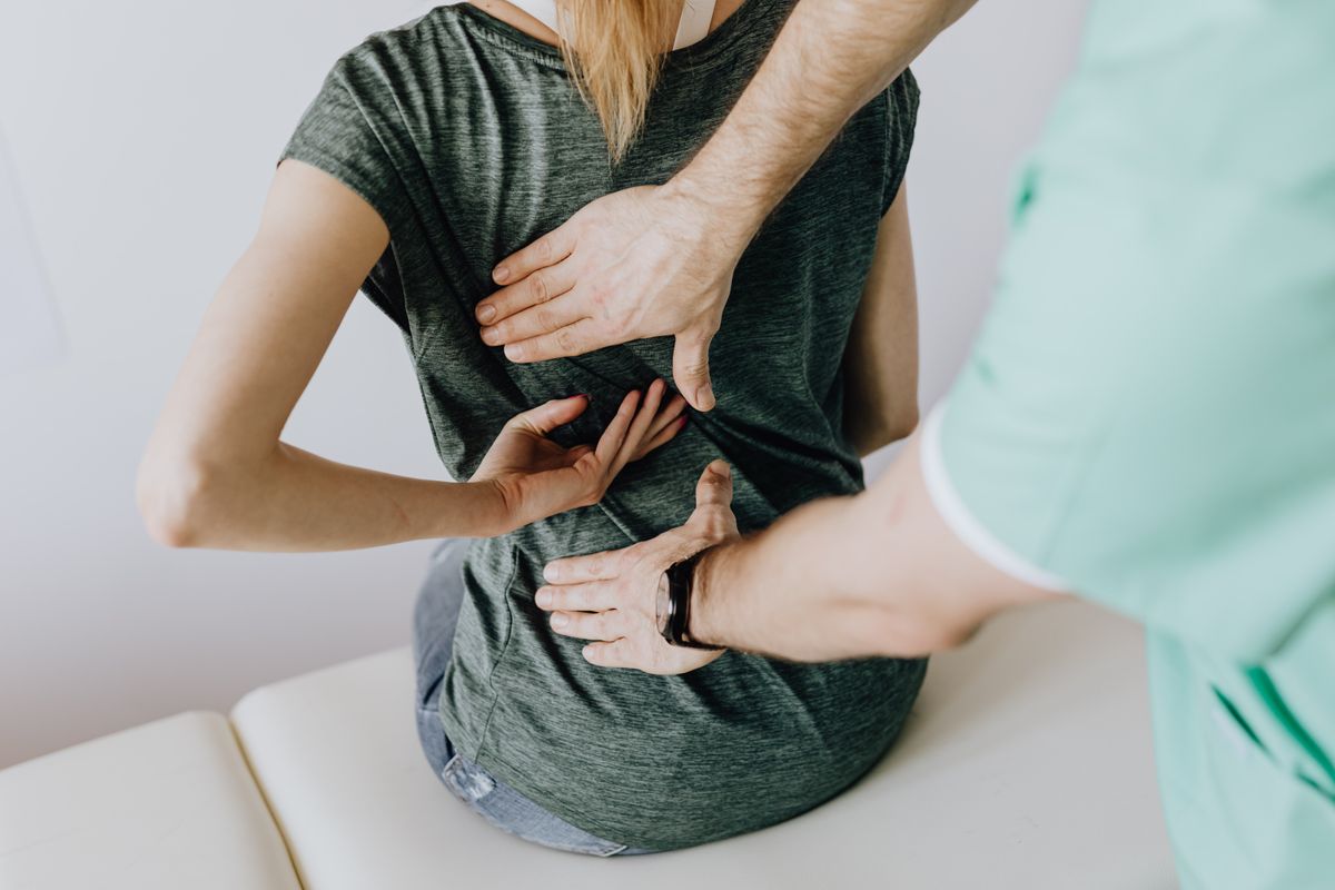 Physiaura physiotherapist assessing a patient’s back and shoulder movement